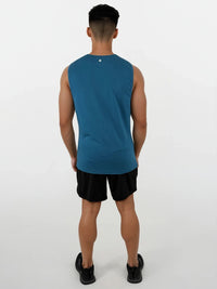 Person wearing a blue sleeveless shirt and black shorts on a white background