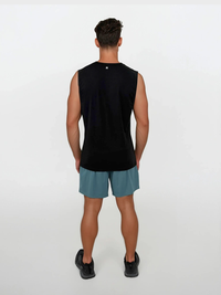 Person wearing a black sleeveless shirt and teal shorts on a white background