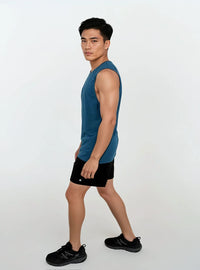 Man wearing a blue sleeveless shirt and black shorts on a white background