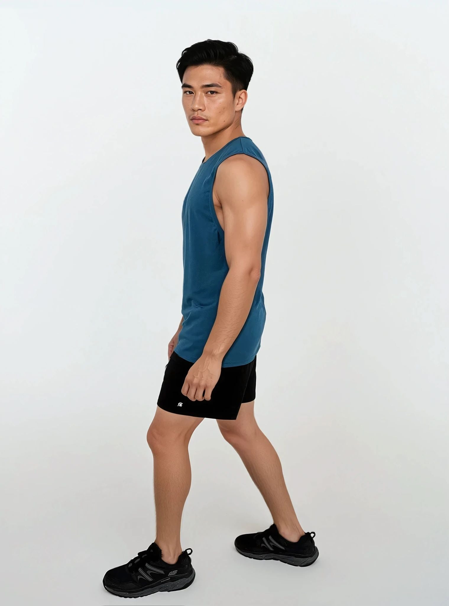 Man wearing a blue sleeveless shirt and black shorts on a white background